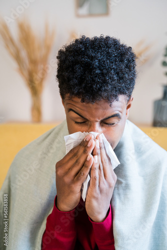 African American boy with cold and wiping his nose