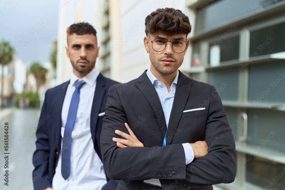 Two hispanic men business workers standing with arms crossed gesture at street Two hispanic men business workers standing with arms crossed gesture at street