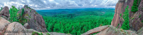 Panoramic view of the dense coniferous forest. Dramatic sky.