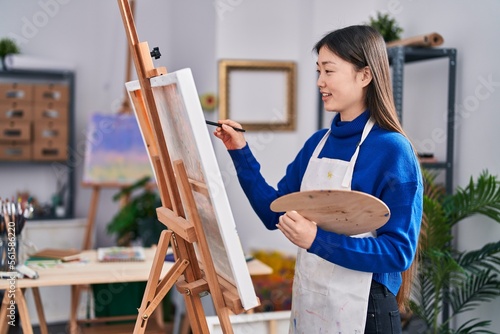 Chinese woman artist smiling confident drawing at art studio
