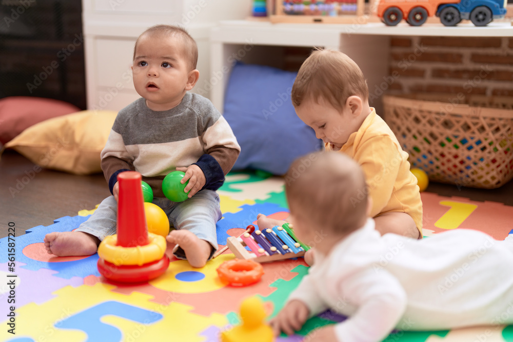 Group of toddlers playing with toys sitting on floor at kindergarten Group of toddlers playing with toys sitting on floor at kindergarten