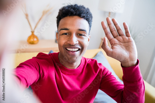 Cheerful black man doing a selfie greeting at camera