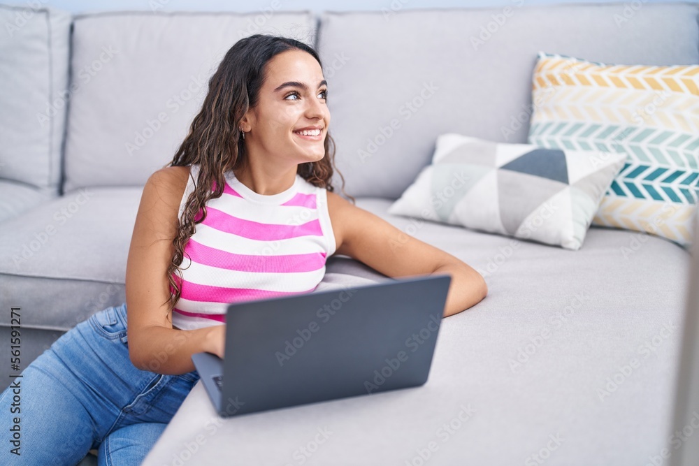 Young beautiful hispanic woman using laptop sitting on floor at home Young beautiful hispanic woman using laptop sitting on floor at home