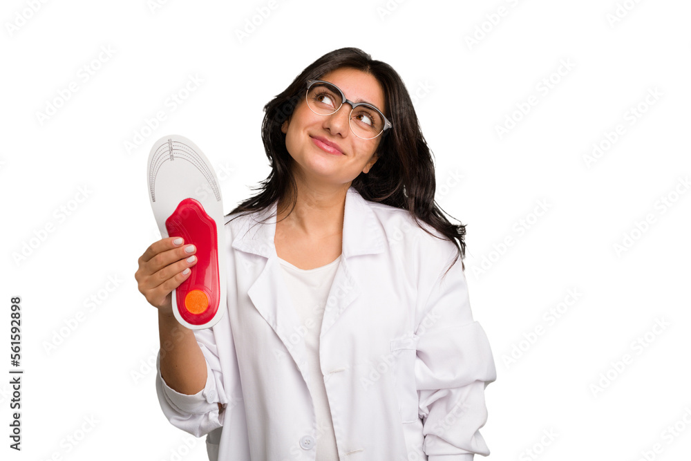 Young indian chiropodist woman holding a insoles for shoes cut out isolated dreaming of achieving goals and purposes Young indian chiropodist woman holding a insoles for shoes cut out isolated dreaming of achieving goals and purposes