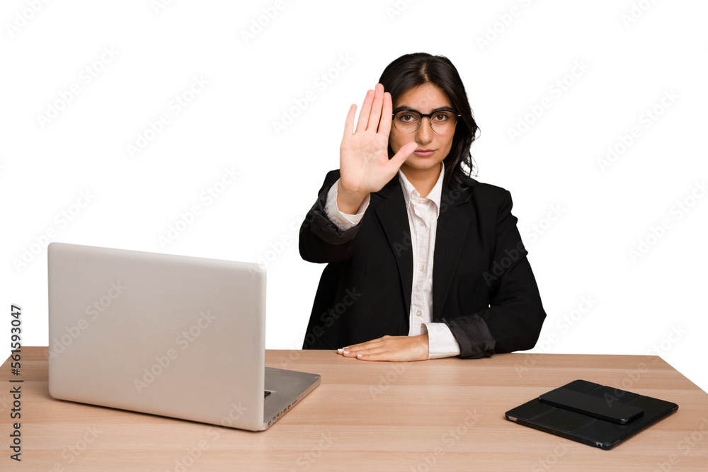 Young indian woman in a table with a laptop and tablet isolated standing with outstretched hand showing stop sign, preventing you. Young indian woman in a table with a laptop and tablet isolated standing with outstretched hand showing stop sign, preventing you.