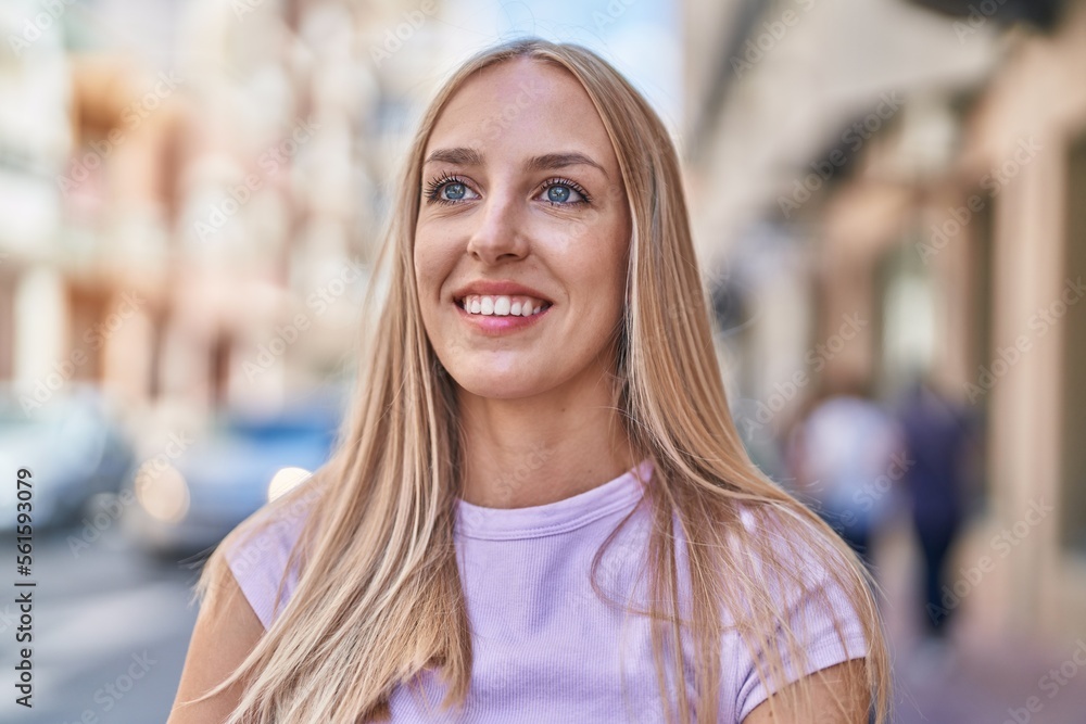 Young blonde woman smiling confident looking to the side at street