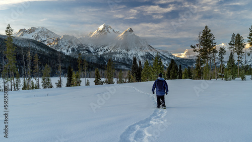 Man on snowshoes walks towards the Sawtooth Mountains photo