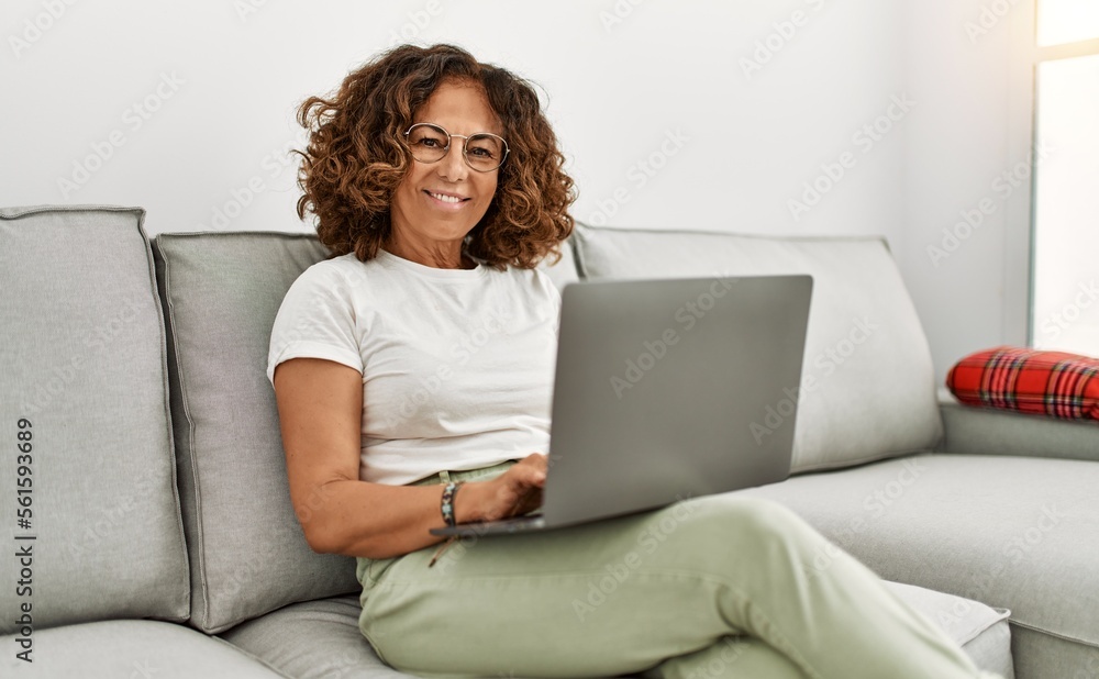 Middle age hispanic woman smiling confident using laptop at home Middle age hispanic woman smiling confident using laptop at home