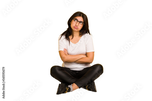 Young indian woman sitting on the floor cut out isolated tired of a repetitive task.