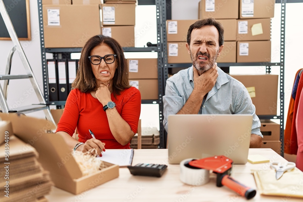 Middle age couple working at small business ecommerce touching painful neck, sore throat for flu, clod and infection Middle age couple working at small business ecommerce touching painful neck, sore throat for flu, clod and infection