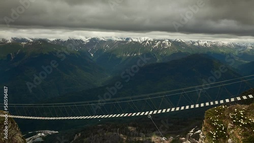 suspension bridge between mountains,extreme entertainment in the mountains, crossing the rope bridge