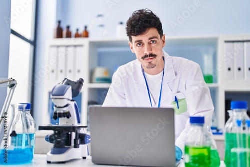Young caucasian man scientist using laptop at laboratory