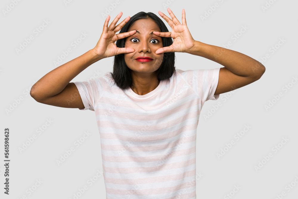 Young Indian woman cut out isolated on white background keeping eyes opened to find a success opportunity. Young Indian woman cut out isolated on white background keeping eyes opened to find a success opportunity.