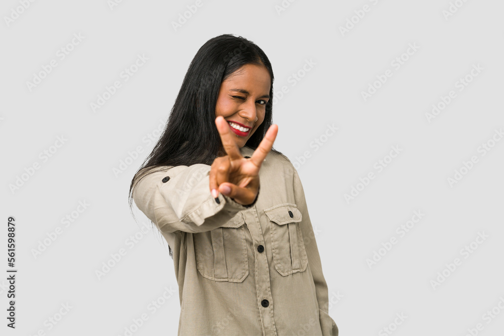 Young Indian woman cut out isolated on white background showing number two with fingers. Young Indian woman cut out isolated on white background showing number two with fingers.