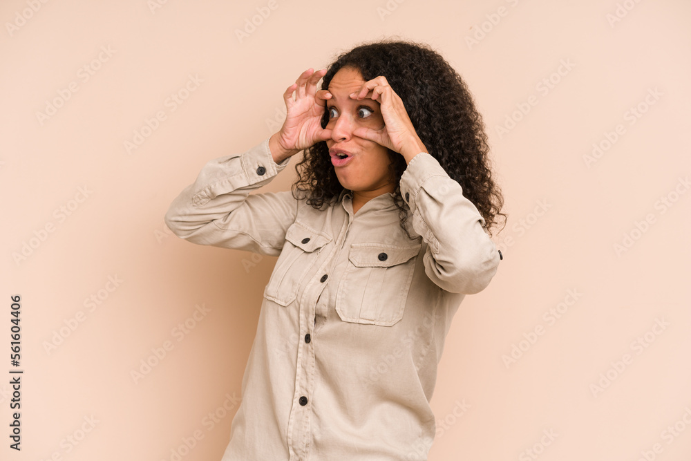 Young african american curly woman isolated keeping eyes opened to find a success opportunity. Young african american curly woman isolated keeping eyes opened to find a success opportunity.