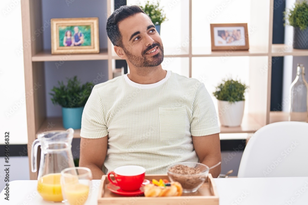 Hispanic man with beard eating breakfast looking to side, relax profile pose with natural face and confident smile. Hispanic man with beard eating breakfast looking to side, relax profile pose with natural face and confident smile.
