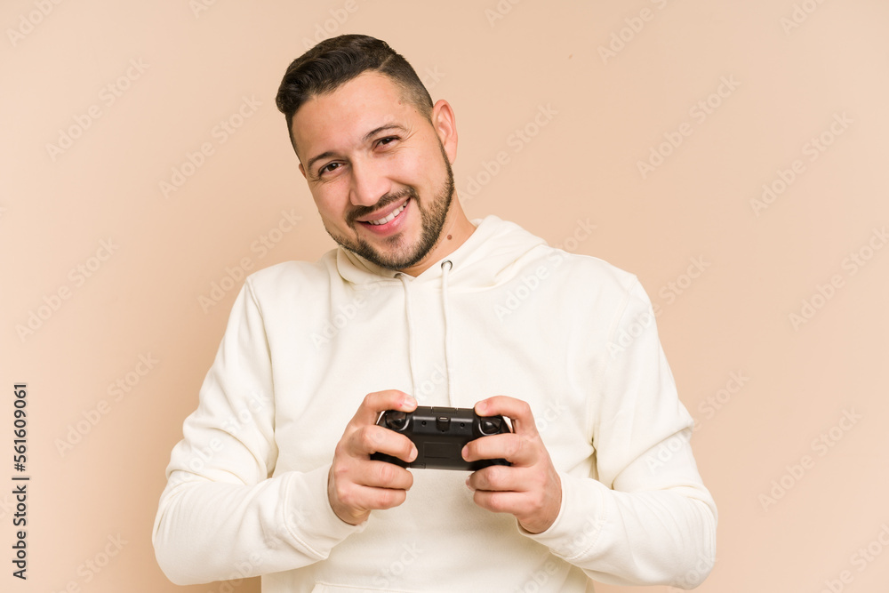 Adult latin man playing with a game controller isolated Adult latin man playing with a game controller isolated