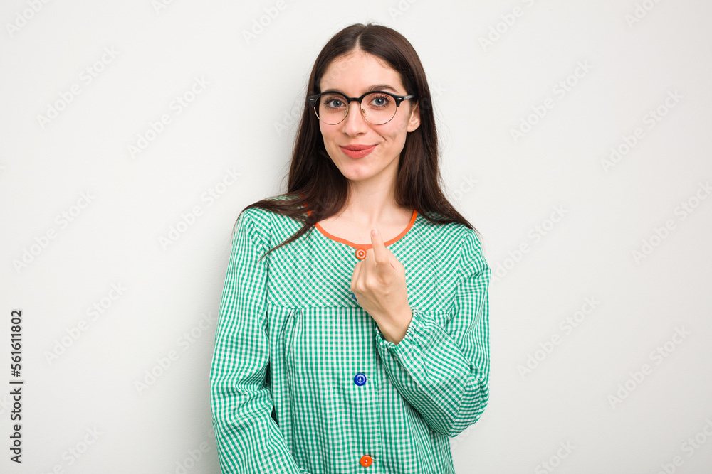 Young caucasian child education teacher isolated on white background pointing with finger at you as if inviting come closer. Young caucasian child education teacher isolated on white background pointing with finger at you as if inviting come closer.