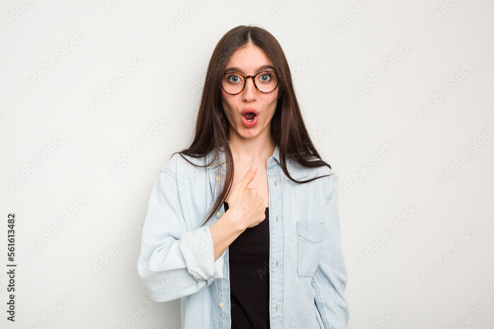 Young caucasian woman isolated on white background surprised pointing with finger, smiling broadly. Young caucasian woman isolated on white background surprised pointing with finger, smiling broadly.