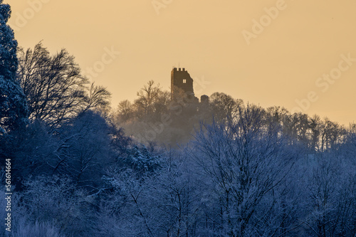 Ruin of Drachenfels or Dragons Rock at sunrise in winter with ice frosted forest photo