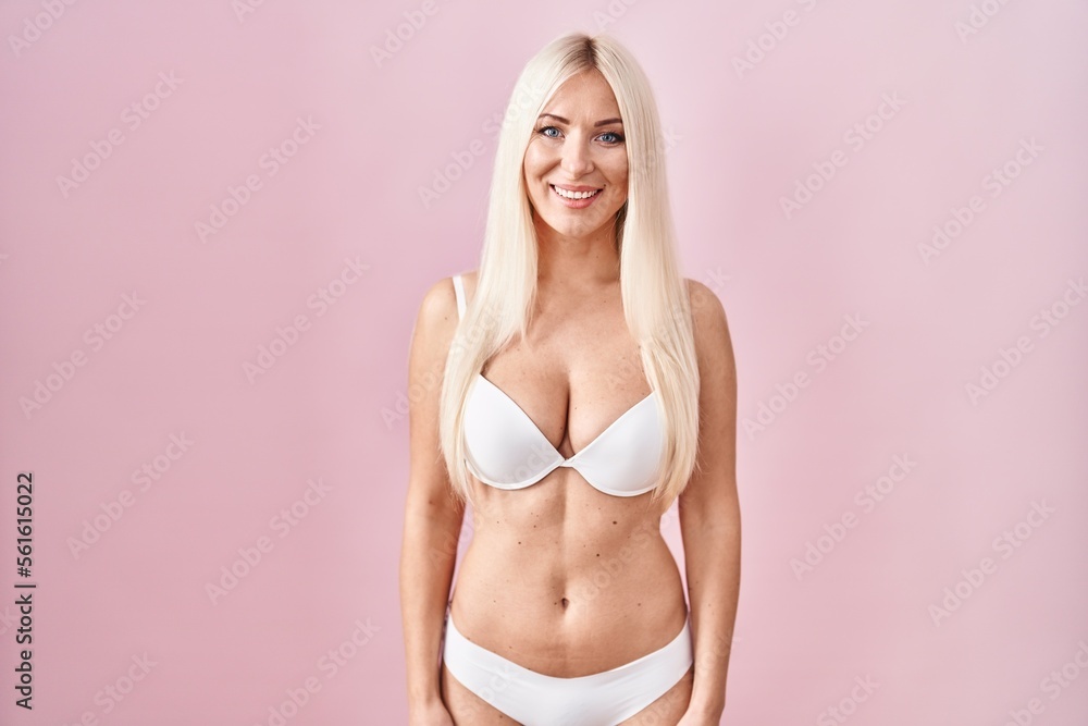 Fototapeta premium Caucasian woman wearing lingerie over pink background with a happy and cool smile on face. lucky person.