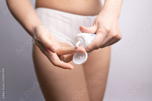 woman hands applying moisturizer cream on thigh. Stretch marks on female legs.