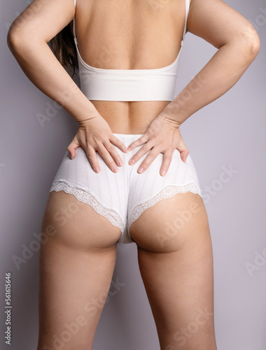 Back view of Asian woman in great shape, perfect body shape. Parts of a female body in underwear, studio shot.