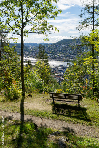 Landscape with an empty park bench and view from park hill to the river Drammenselva and the town Drammen