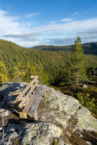 Norwegian mountain landscape in Sigdal region with wooden bench on rock in the foreground