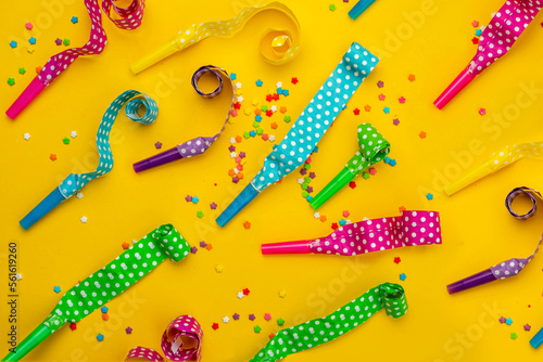 Abstract colored party background. Multi-colored party horns, serpentine ribbons, colored sprinkles scattered on bright paper. Base for design nice backdrop, wallpaper, poster photo