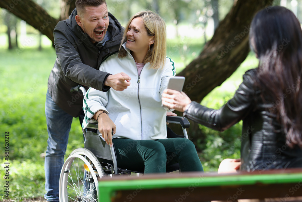 Deceased woman in wheelchair with her friends having fun while walking in park. Deceased woman in wheelchair with her friends having fun while walking in park.