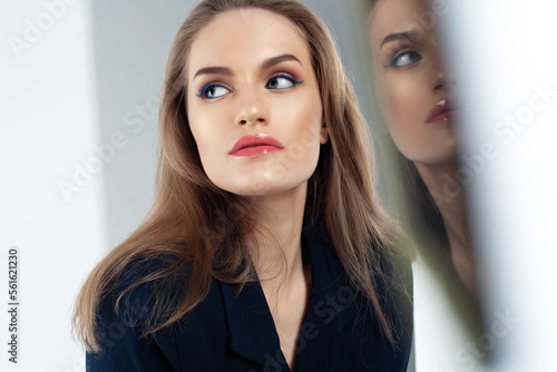 Portrait of young business woman with her reflection in mirror