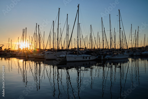 Yacht parking in the marina at sunset. Sea bay with yachts at sunset. Moored yachts. Marina, port. reflection of boat masts in sea water at sunset. Torrevieja, Alicante, Spain