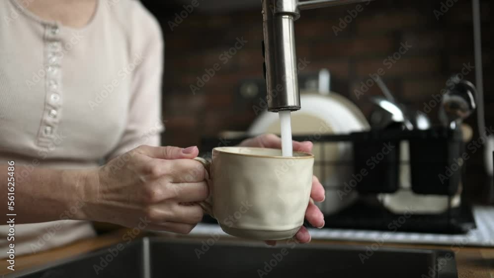 Girl filling cup with tap water Girl filling cup with tap water