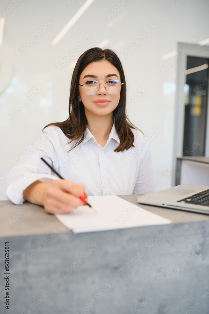 Young female receptionist working in office