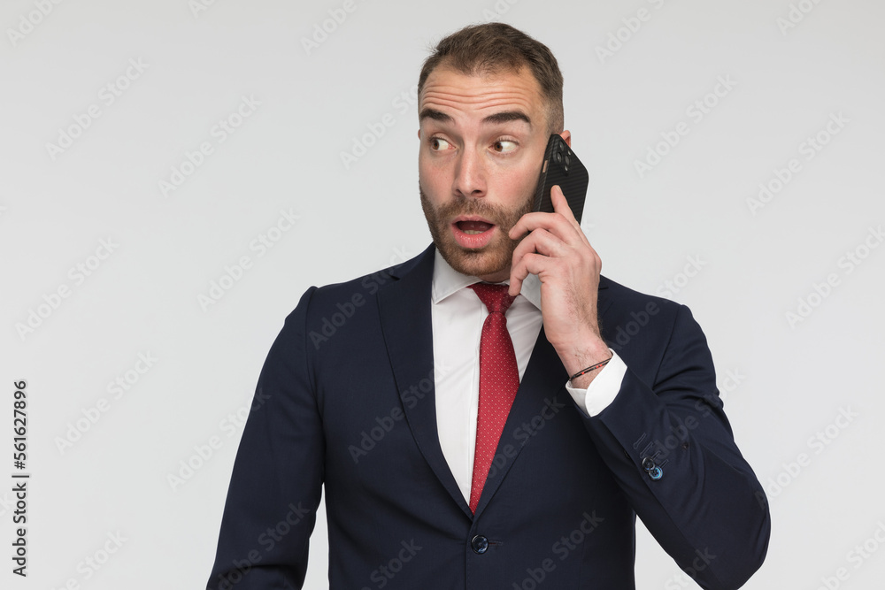 surprised young man having a phone conversation and looking to side surprised young man having a phone conversation and looking to side