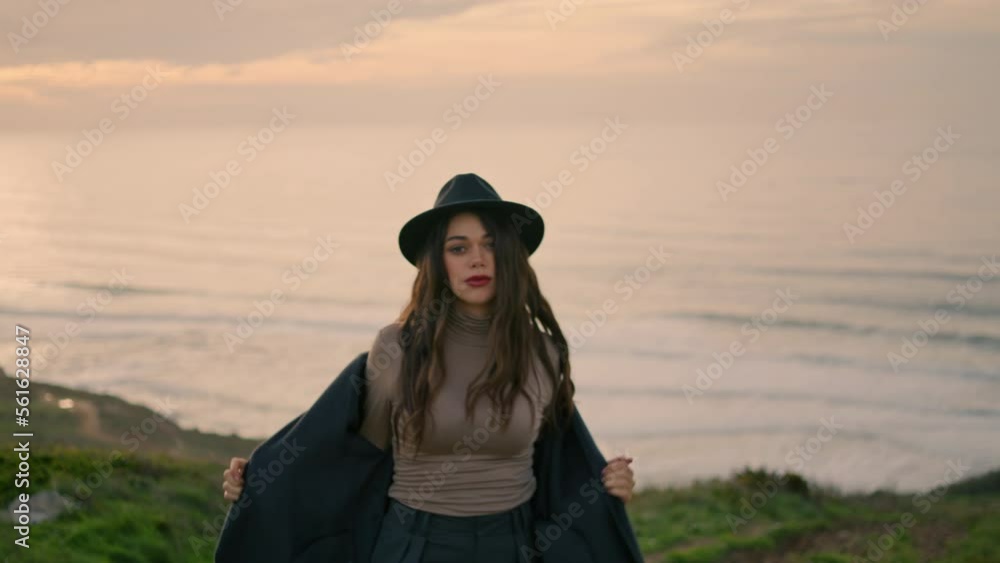 Young lady walking coast with beautiful ocean backdrop. Woman posing at evening. Young lady walking coast with beautiful ocean backdrop. Woman posing at evening.