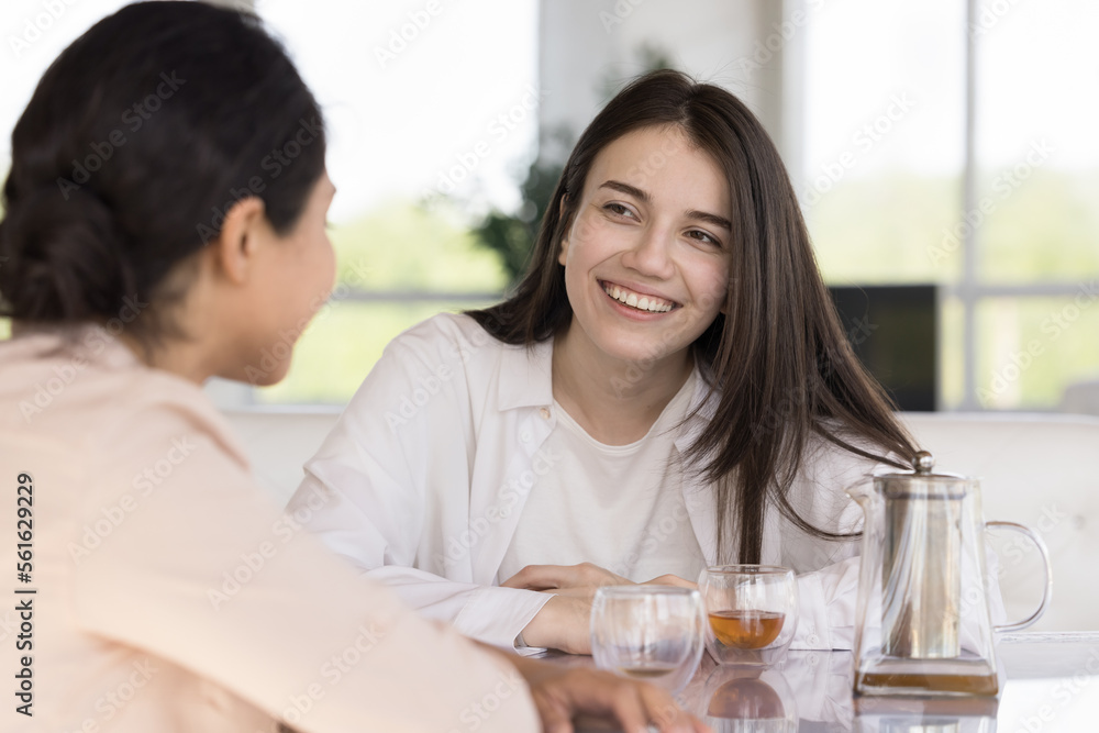 Happy diverse female friends chatting over cup of tea in cafe, meeting for breakfast in coffee shop, talking, laughing, enjoying friendship, informal social communication Happy diverse female friends chatting over cup of tea in cafe, meeting for breakfast in coffee shop, talking, laughing, enjoying friendship, informal social communication