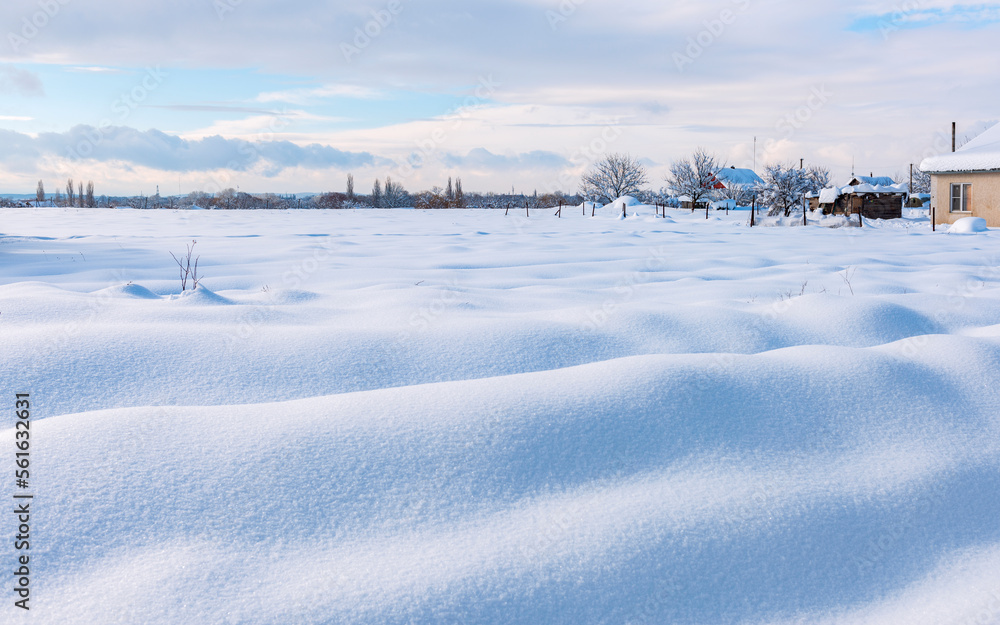 Agricultural field at the edge of the village covered with deep snow Agricultural field at the edge of the village covered with deep snow