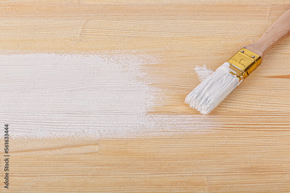 white paint with a brush on a wooden background with texture white paint with a brush on a wooden background with texture