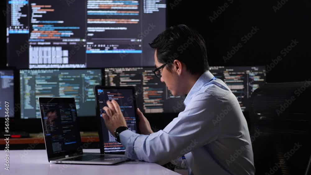 Side View Of Asian Male Programmer Looking At Database On Tablet While Writing Code By A Laptop Using Multiple Monitors Showing Database On Desktops In The Office
Side View Of Asian Male Programmer Looking At Database On Tablet While Writing Code By A Laptop Using Multiple Monitors Showing Database On Desktops In The Office