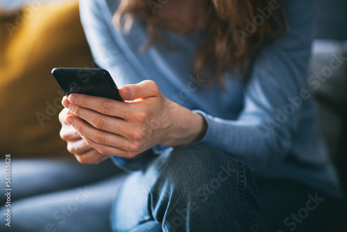 Young woman using a mobile phone on the couch at home