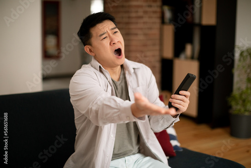 Foto Mature korean man emotionally reacting to defeat of sports team or shocking news