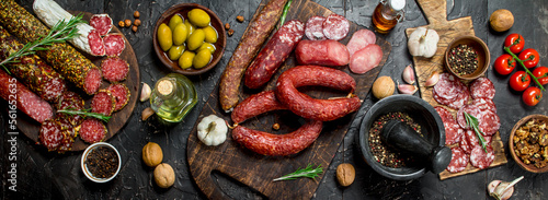 Variety of smoked salami with olives, herbs and spices.