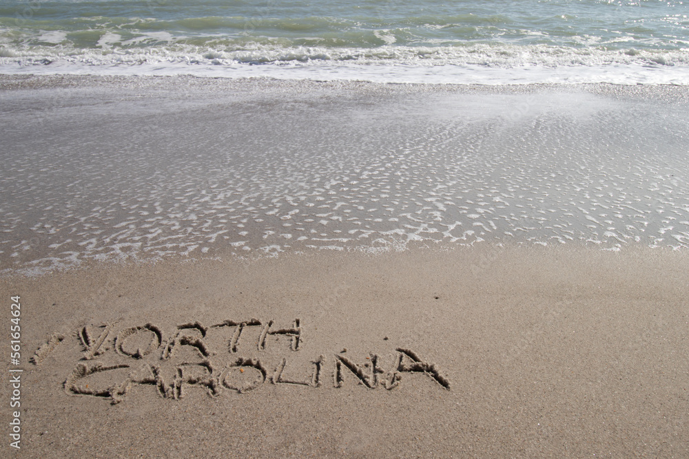 Fototapeta premium North Carolina written in the sand at the beach