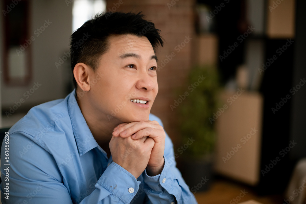 Dreamy middle aged asian businessman thinking of new business strategy, looking aside and smiling, free space Dreamy middle aged asian businessman thinking of new business strategy, looking aside and smiling, free space