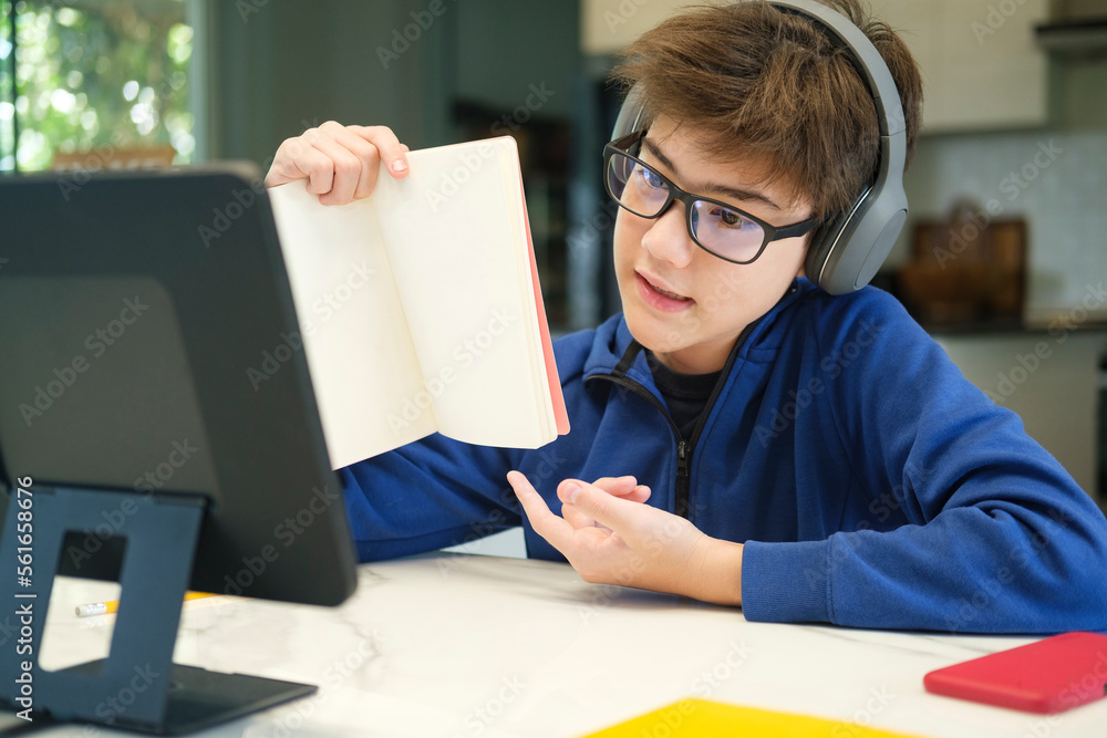 © Cavan Images - Student boy with tablet computer learning at home