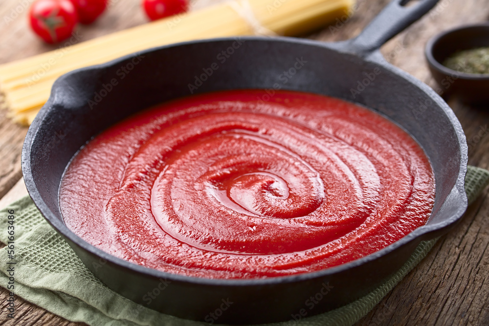 Tomato paste in cast iron skillet, with dry spaghetti, cherry tomato