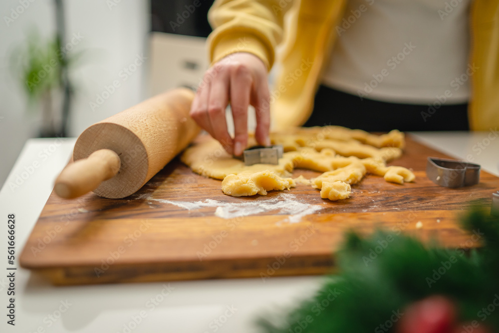 Top and side view of mother and daughter preparing gingerbread cookies with rolling pin in their kitchen in different shapes heart and stars 