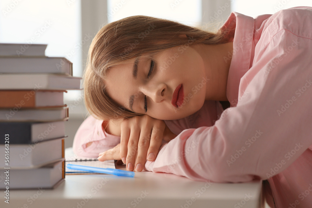 Young tired woman sleeping near books at white table indoors, closeup Young tired woman sleeping near books at white table indoors, closeup